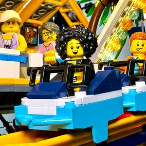 Nicole Angela Buck mit ihrer selbst gebauten LEGO® Achterbahn – Sinnbild für Innovation, Spaß und Teamwork im Business.